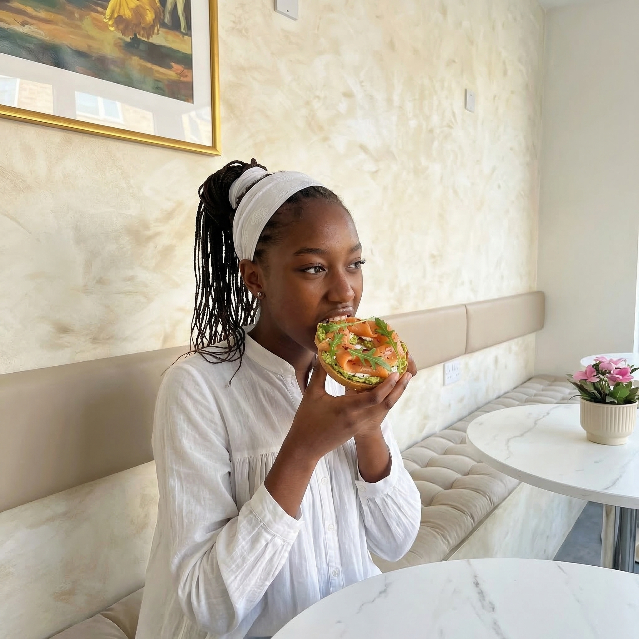 Customer enjoying a bagel at Base Wellness Cafe